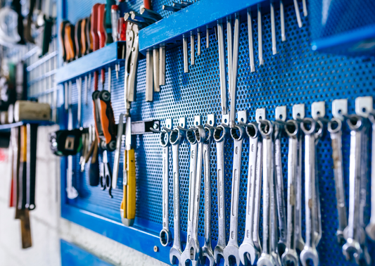 A mechanic is servicing a motorcycle and doing an oil change in his workshop