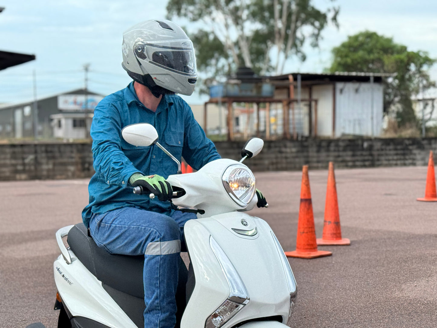 Person on a white scooter with orange traffic cones in an outdoor setting, getting a scooter licence in Darwin.